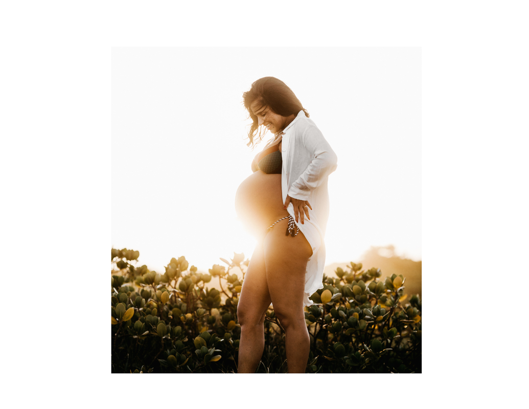 Alt= Pregnant women the the glow of a sunset 